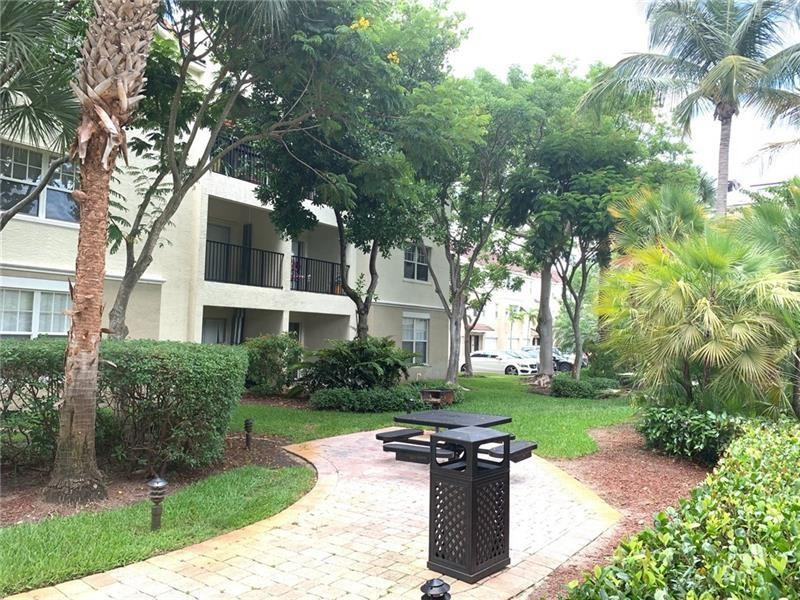 5980 West Sample Road, Unit 303 Coral Springs, FL 33067 - Photo 24 of 32 a view of a house with backyard and a tree