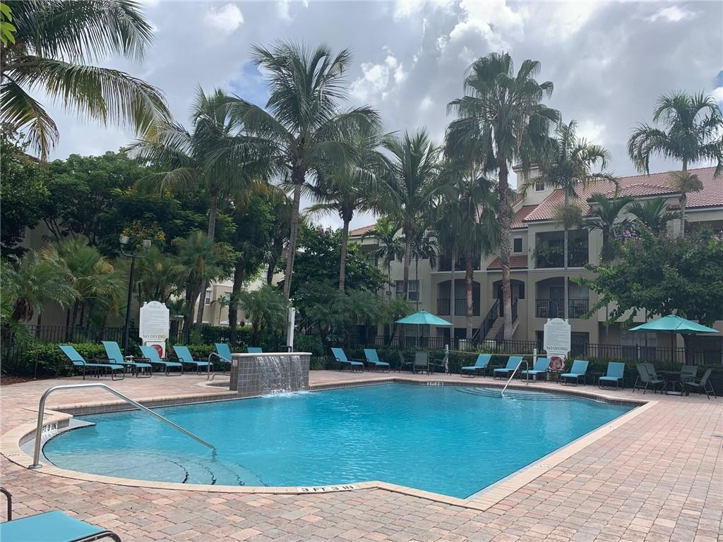 5980 West Sample Road, Unit 303 Coral Springs, FL 33067 - Photo 31 of 32 a view of a swimming pool with palm trees