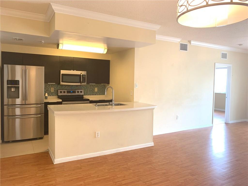 5980 West Sample Road, Unit 303 Coral Springs, FL 33067 - Photo 6 of 32 a kitchen with stainless steel appliances a refrigerator and a stove