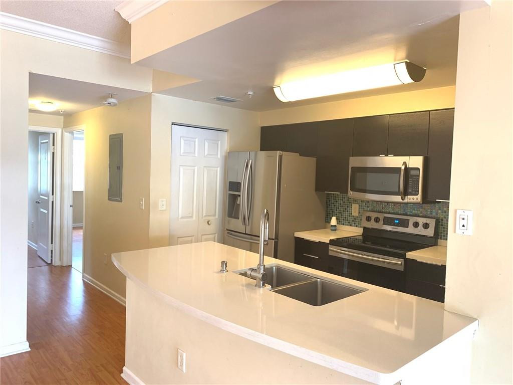 5980 West Sample Road, Unit 303 Coral Springs, FL 33067 - Photo 7 of 32 a kitchen with stainless steel appliances a sink and a refrigerator