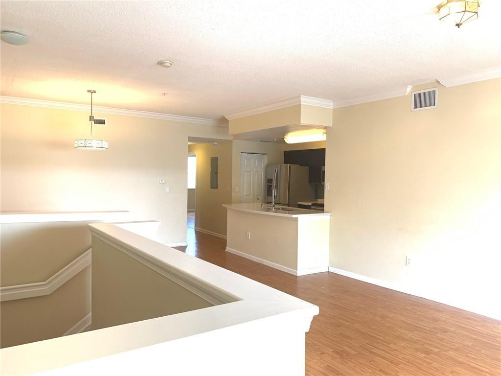 5980 West Sample Road, Unit 303 Coral Springs, FL 33067 - Photo 10 of 32 a large white kitchen with wooden floor