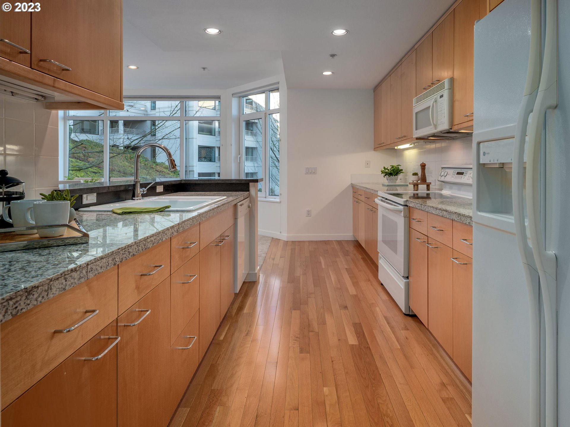 2445 Northwest Westover Road, Unit 314 Portland, OR 97210 - Photo 13 of 32 a large kitchen with stainless steel appliances granite countertop a lot of counter space and wooden floor