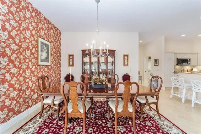 a dining room with furniture a chandelier and wooden floor