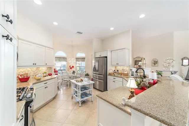 a room with stainless steel appliances kitchen island granite countertop furniture and a view of living room