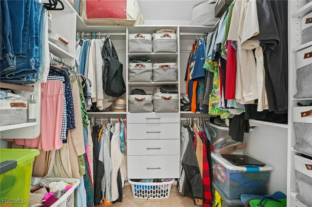 a view of walk in closet with clothes and shoes