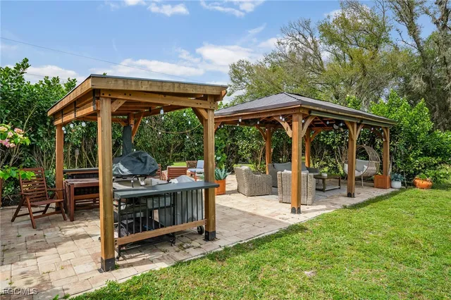 a view of a chair and table in backyard of the house