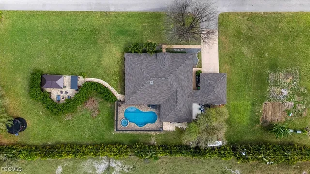 an aerial view of a house with a yard basket ball court and outdoor seating