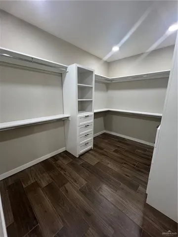 a room with walk in closet and wooden floor