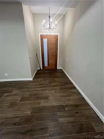 a view of a room with wooden floor and chandelier