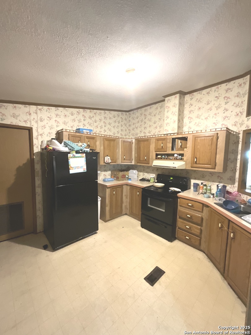 1 3rd Street Pettus, TX 78146 - Photo 13 of 16 a kitchen with stainless steel appliances granite countertop a refrigerator and a stove