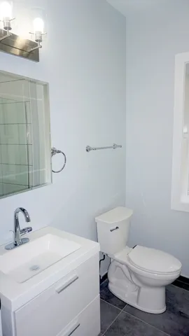 a white toilet sitting next to a bathroom sink
