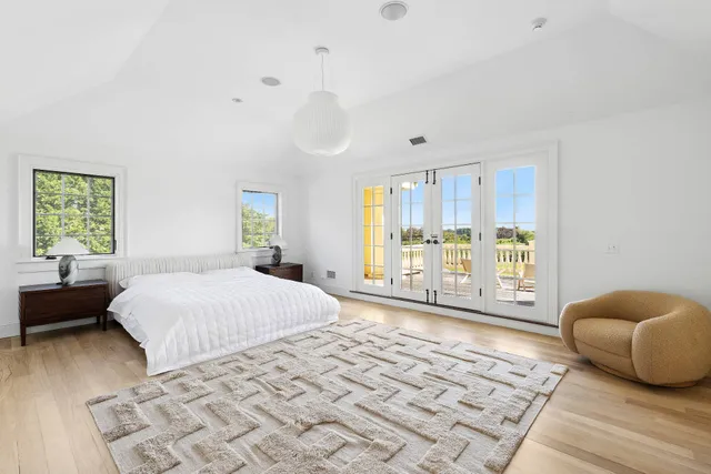 a spacious bedroom with a bed a table and chair