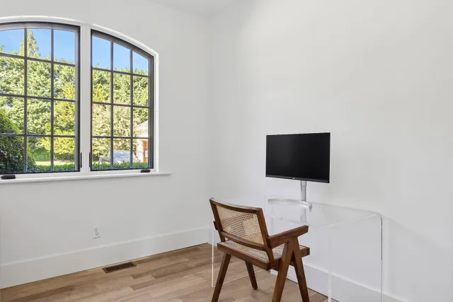 a view of a workspace with furniture and a window
