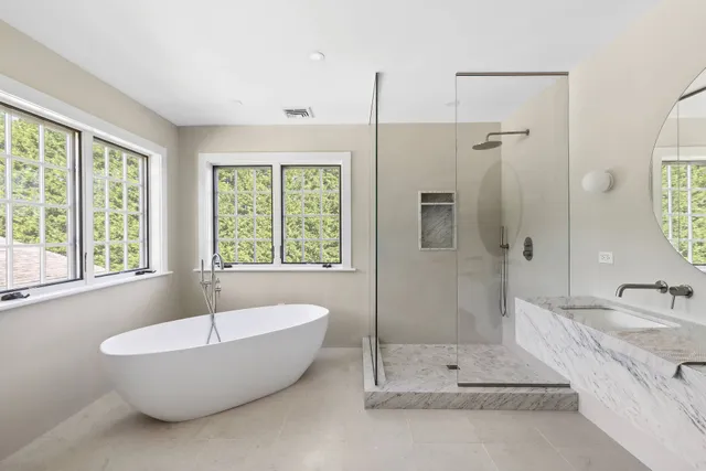 a bathroom with a tub a sink and a shower