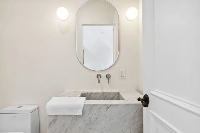 a bathroom with a sink a toilet and a mirror