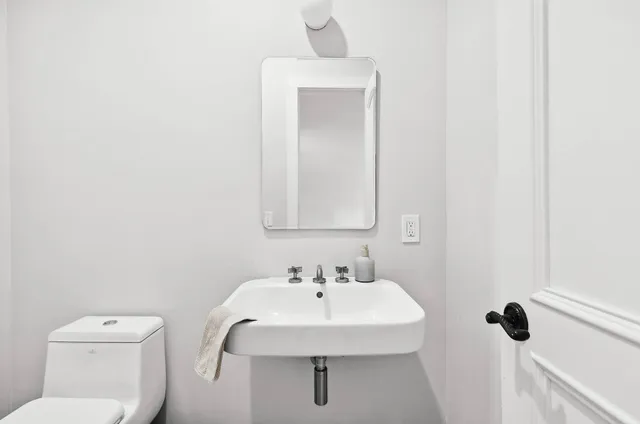 a bathroom with a sink a toilet and a mirror