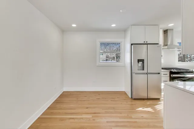a view of a kitchen with a sink refrigerator and wooden floor