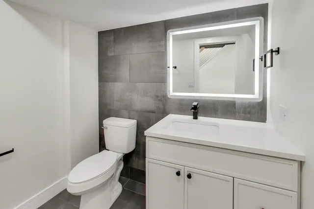 a bathroom with a sink a toilet and a mirror