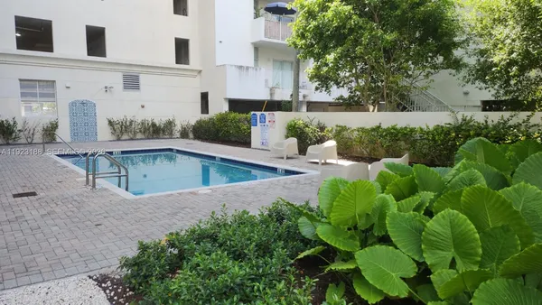 a view of backyard with swimming pool and outdoor seating
