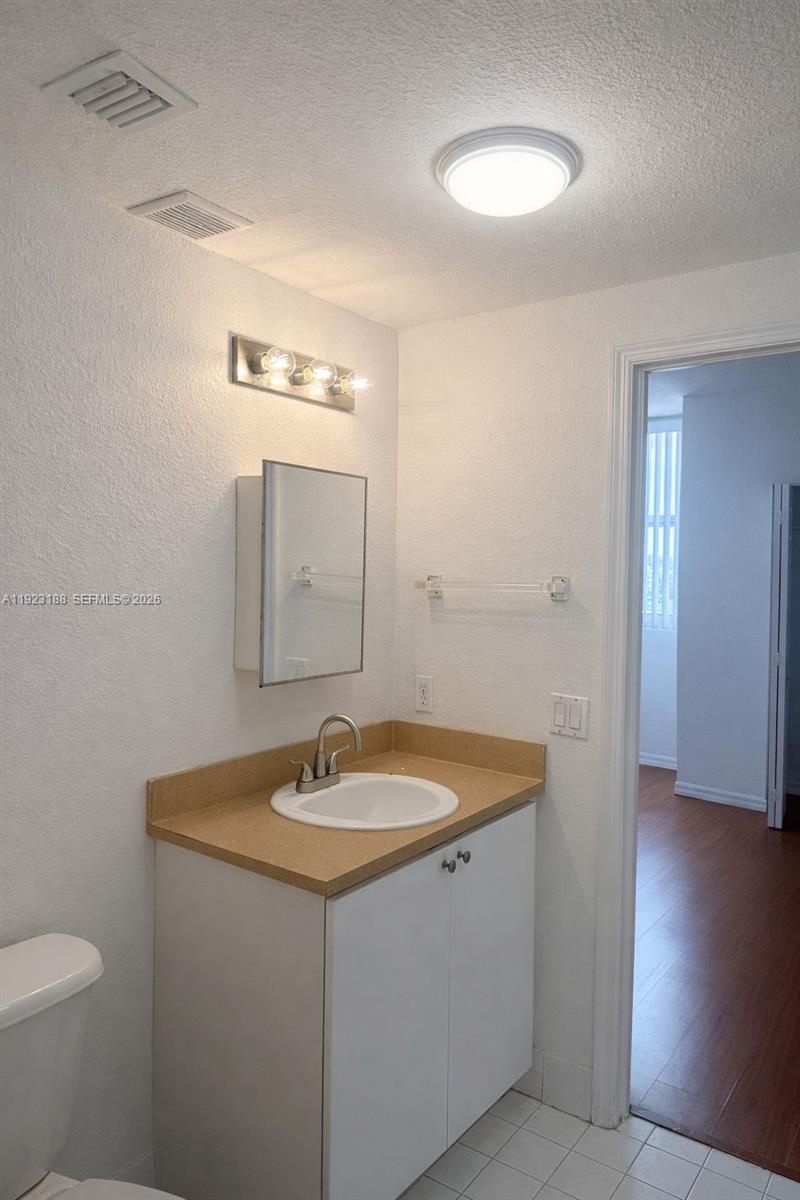 120 Southwest 8th Avenue, Unit 802 Miami, FL 33130 - Photo 5 of 30 a bathroom with a sink a toilet and a mirror