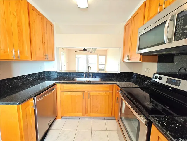 a kitchen with stainless steel appliances granite countertop a sink and a stove