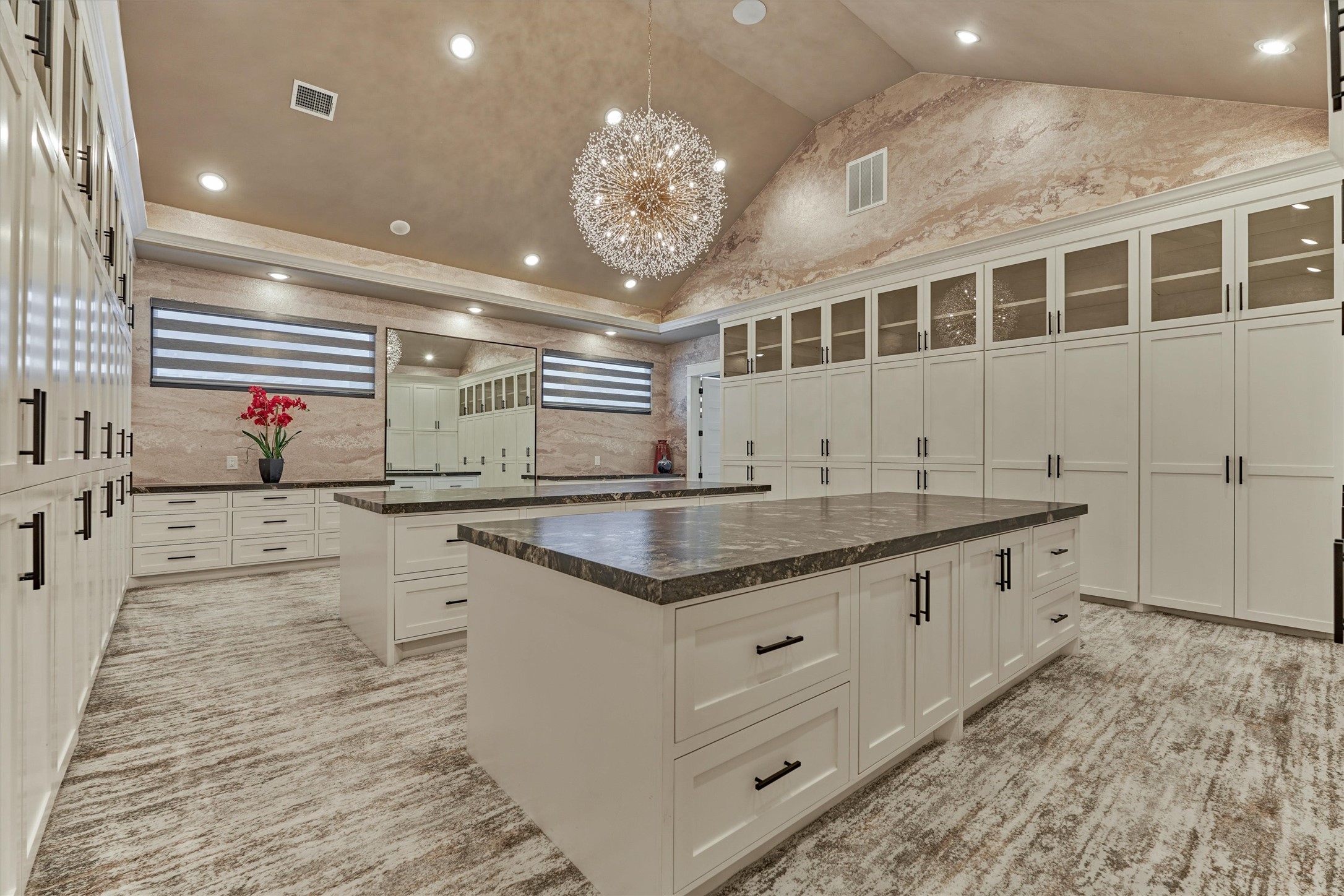 1907 Woerner Road Houston, TX 77090 - Photo 25 of 50 A closet you could live in! Gorgeous primary closet with extensive wardrobe cabinetry plus display cabinets for handbags and shoes. Double islands with storage galore and a sparkling chandelier!