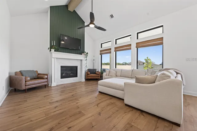 a living room with furniture a flat screen tv and a fireplace