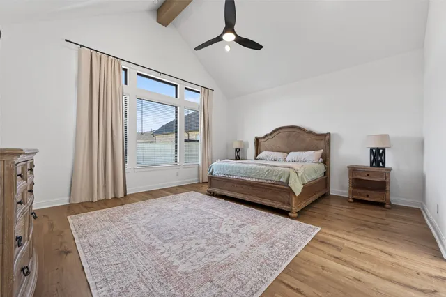 a bedroom with a large bed chandelier and a dresser