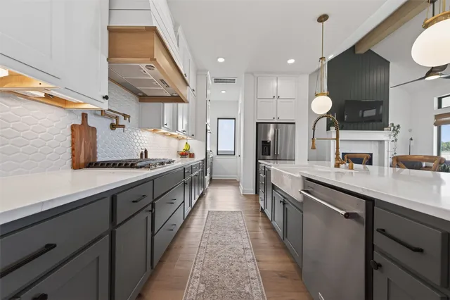 a large kitchen with stainless steel appliances lots of counter space and a sink