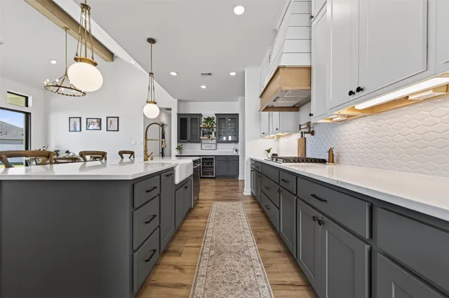 a large kitchen with stainless steel appliances kitchen island a large counter space a sink and a large window