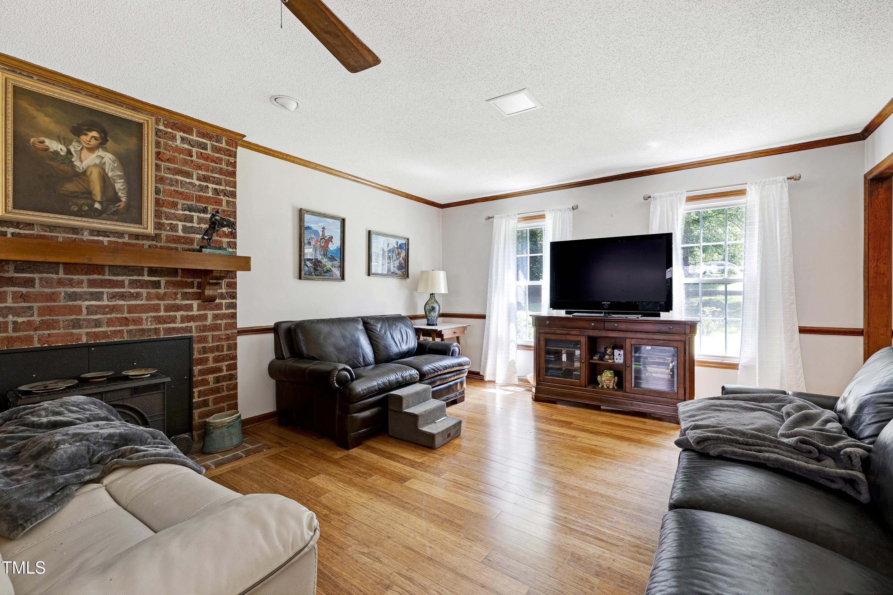 6309 Windy Ridge Court Raleigh, NC 27606 - Photo 9 of 53 a living room with furniture and a flat screen tv