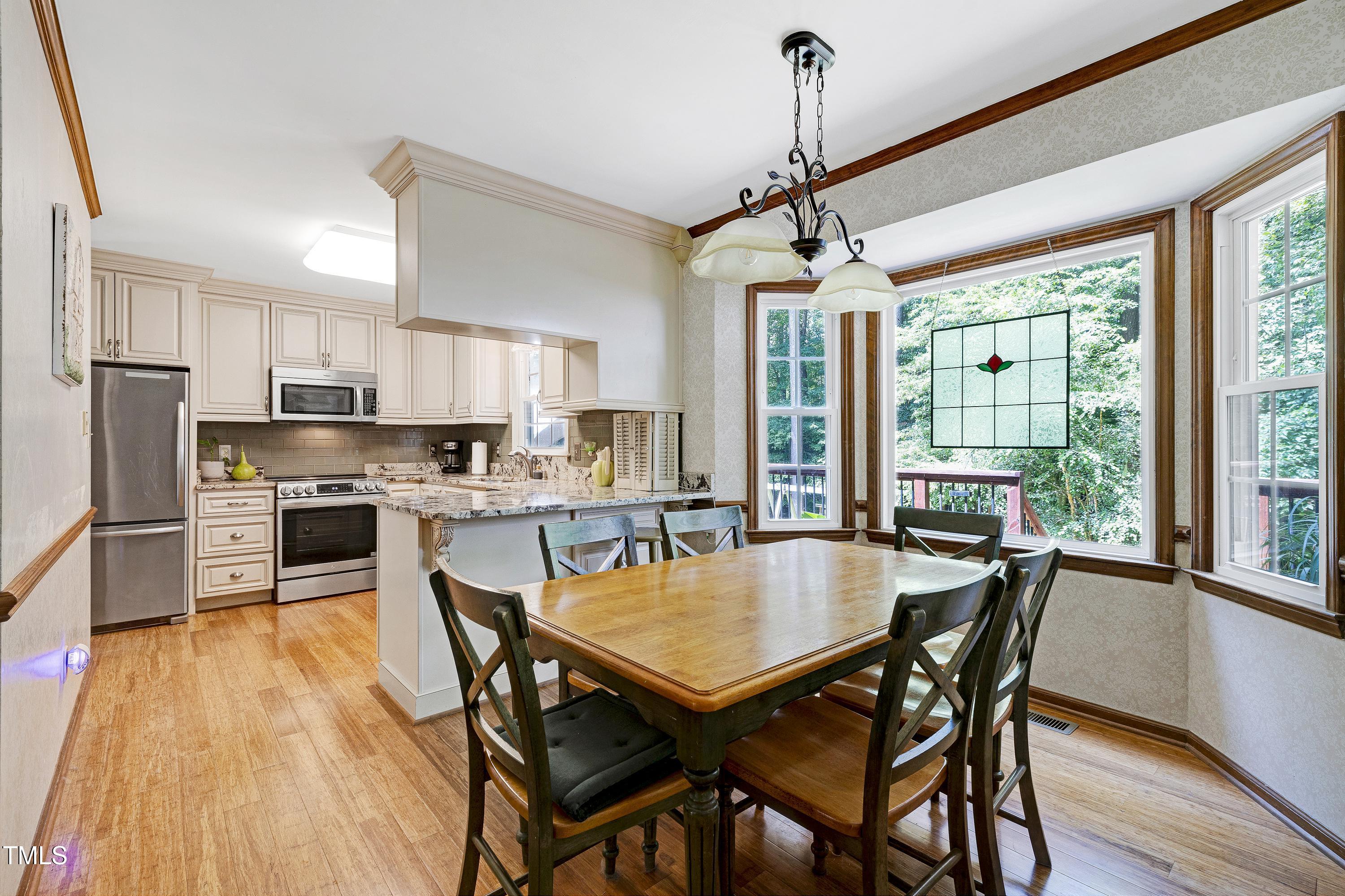 6309 Windy Ridge Court Raleigh, NC 27606 - Photo 10 of 53 a dining room with furniture window wooden floor