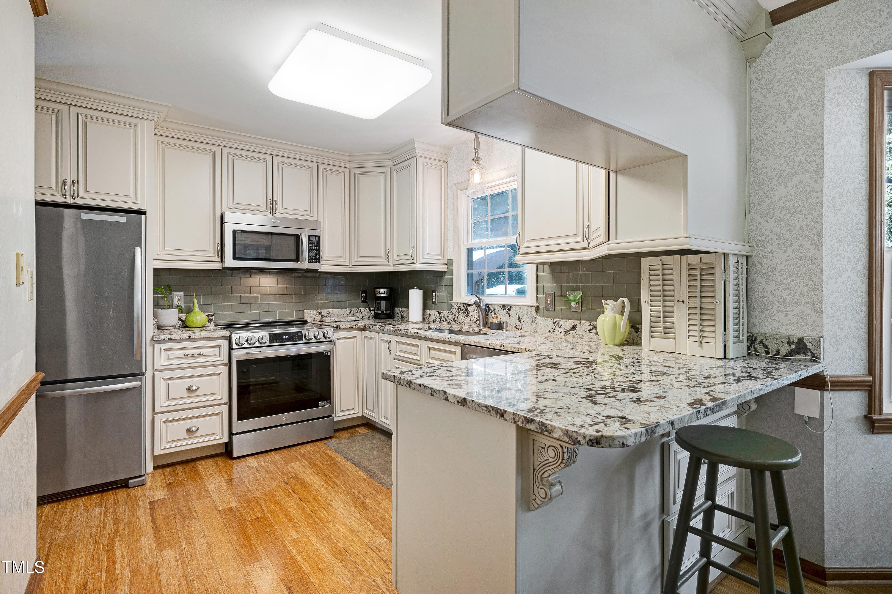 6309 Windy Ridge Court Raleigh, NC 27606 - Photo 11 of 53 a kitchen with stainless steel appliances granite countertop a stove a sink dishwasher a refrigerator and white cabinets with wooden floor