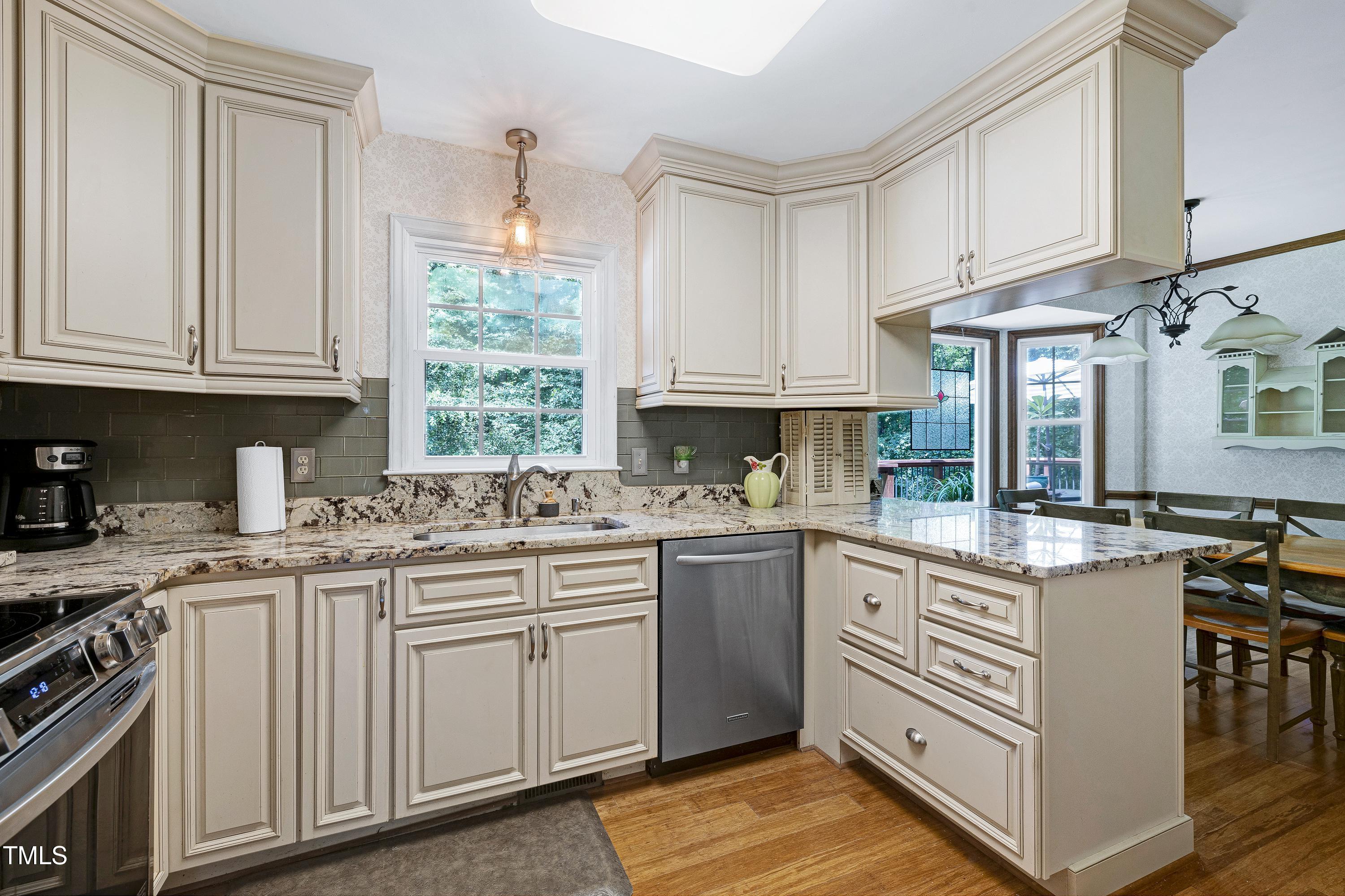 6309 Windy Ridge Court Raleigh, NC 27606 - Photo 12 of 53 a kitchen with granite countertop a sink stove and cabinets