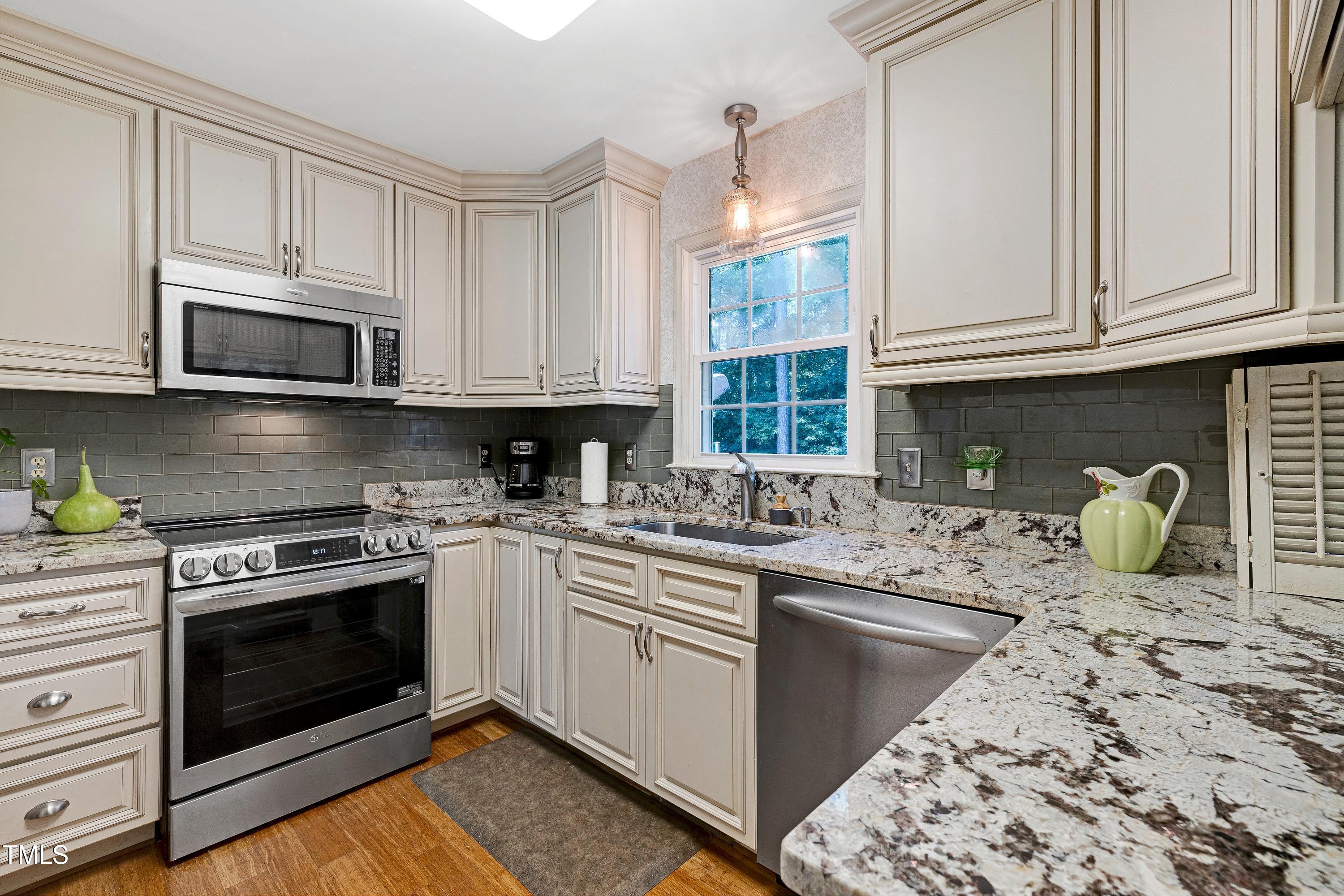 6309 Windy Ridge Court Raleigh, NC 27606 - Photo 13 of 53 a kitchen with stainless steel appliances granite countertop a stove sink microwave and cabinets