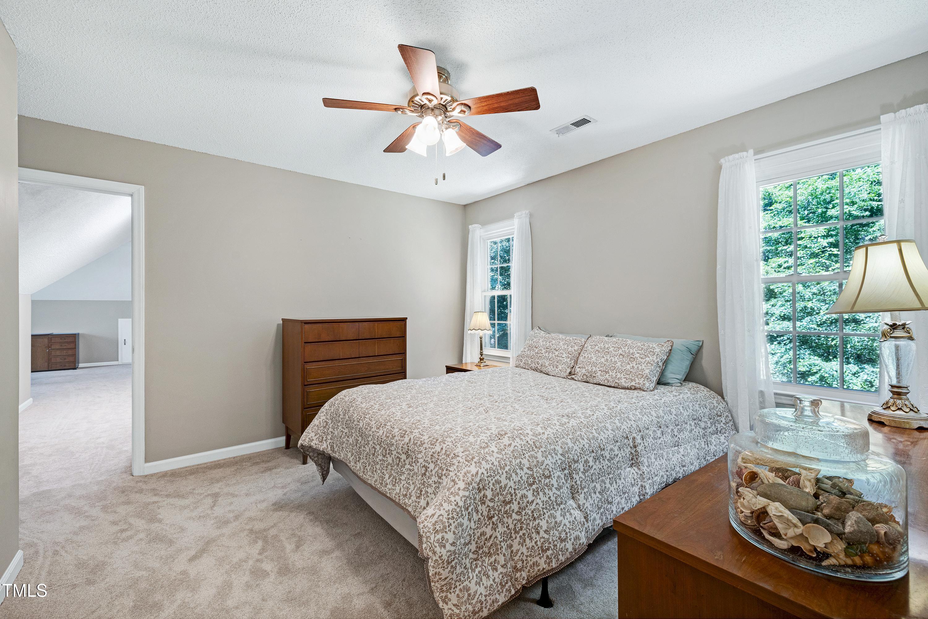 6309 Windy Ridge Court Raleigh, NC 27606 - Photo 21 of 53 a bedroom with a bed and a chandelier