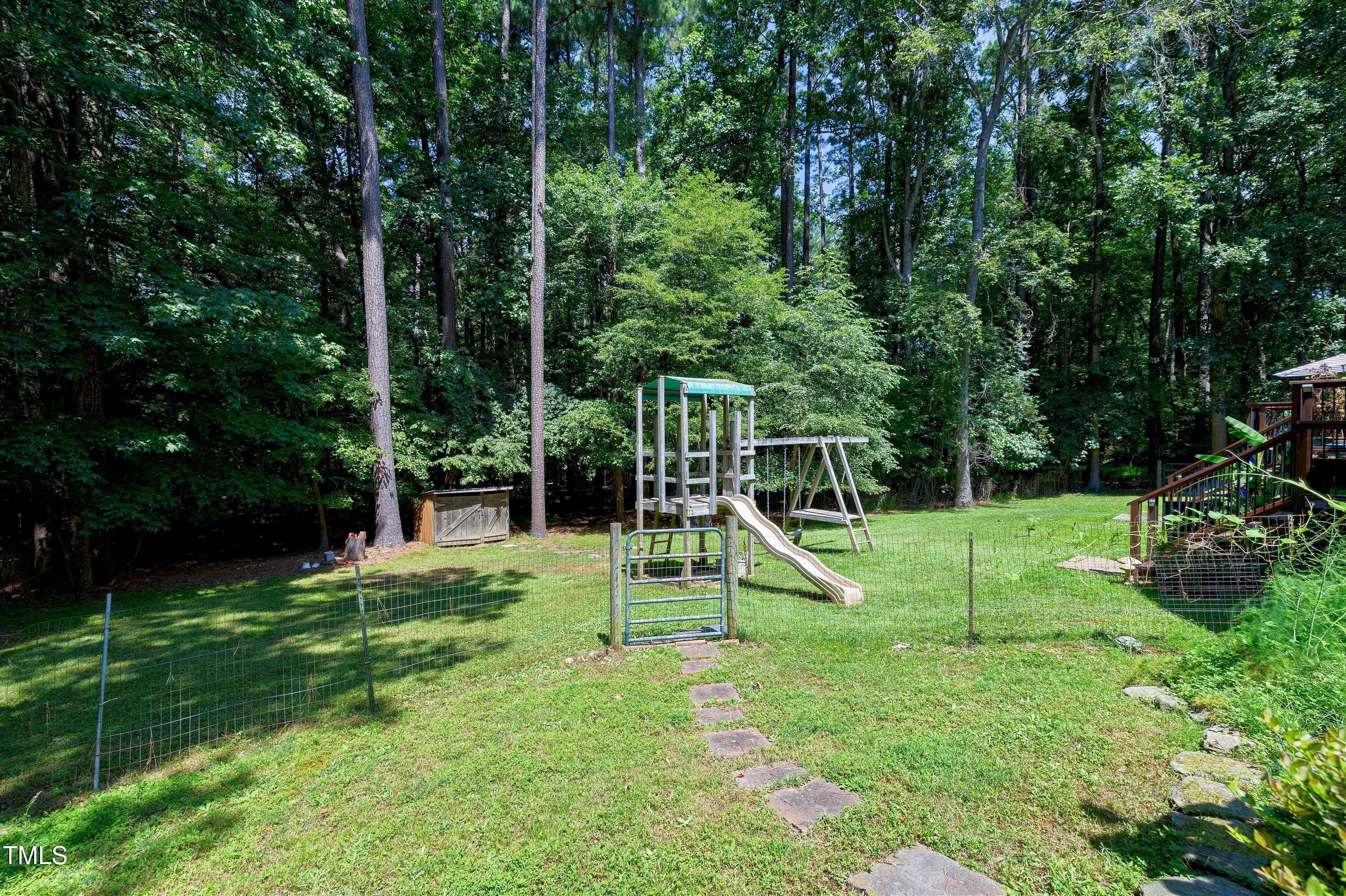 6309 Windy Ridge Court Raleigh, NC 27606 - Photo 42 of 53 a view of a house with a backyard and a slide