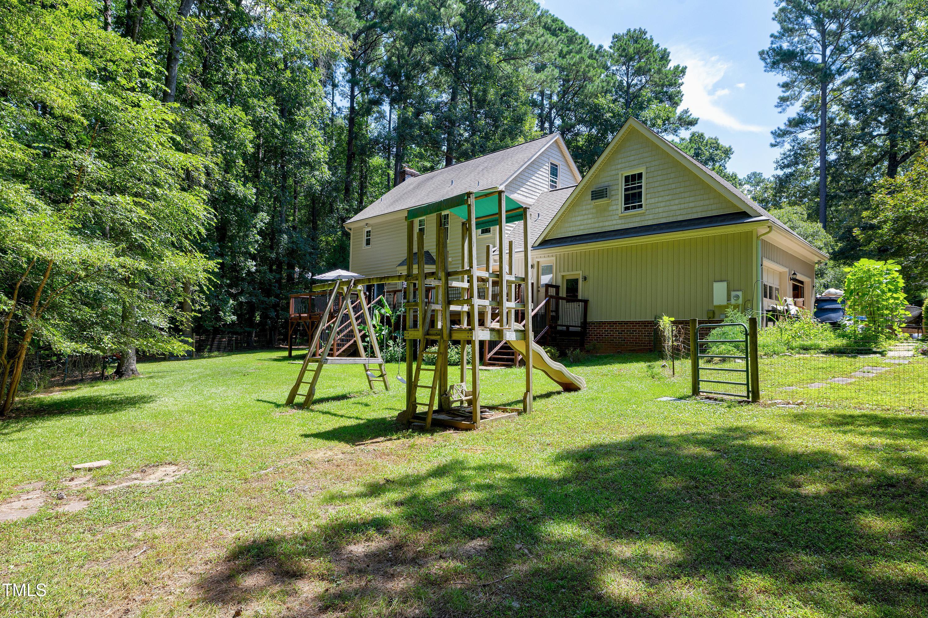 6309 Windy Ridge Court Raleigh, NC 27606 - Photo 43 of 53 a view of playground with a slide and a small yard
