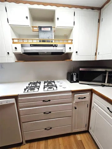 a kitchen with granite countertop white cabinets white appliances and sink