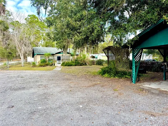 a view of a house with a yard and sitting area