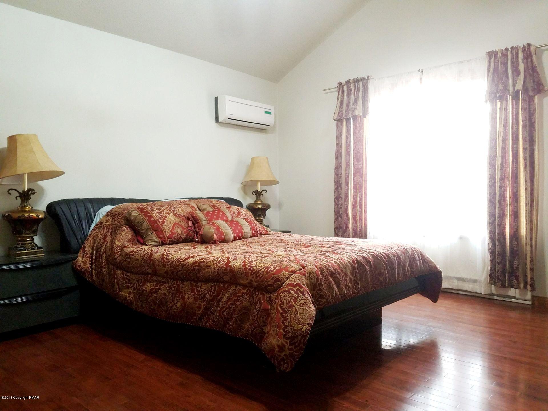 179 Radcliff Road Bushkill, PA 18324 - Photo 10 of 32 a bedroom with a bed and wooden floor