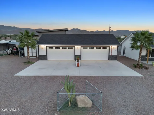 a view of a house with a yard and palm trees