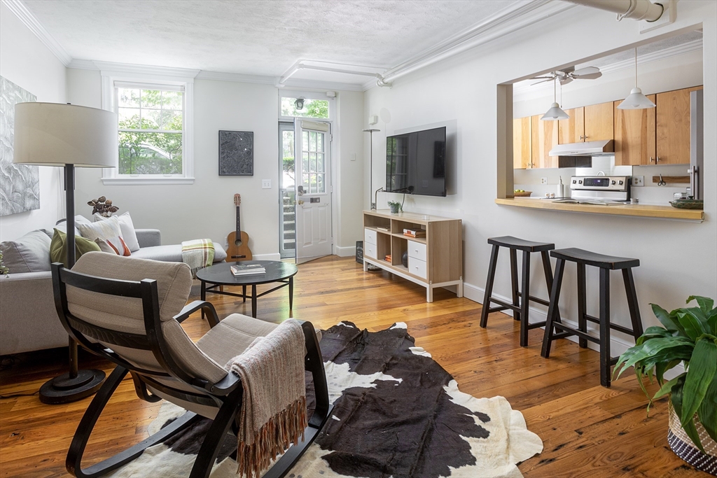 a living room with furniture a flat screen tv and a large window