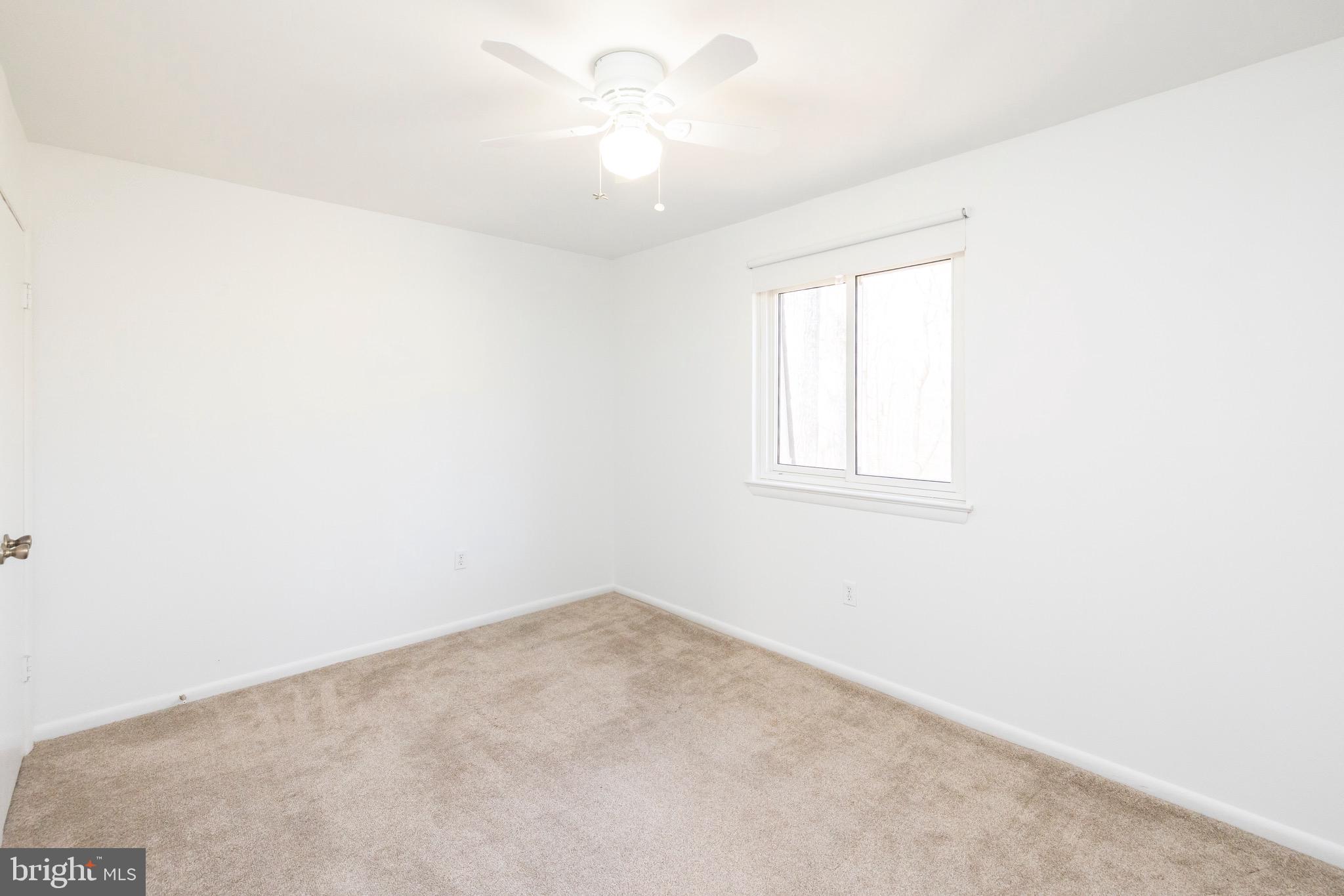 12265 Greenleaf Avenue Potomac, MD 20854 - Photo 14 of 25 an empty room with a window and a ceiling fan