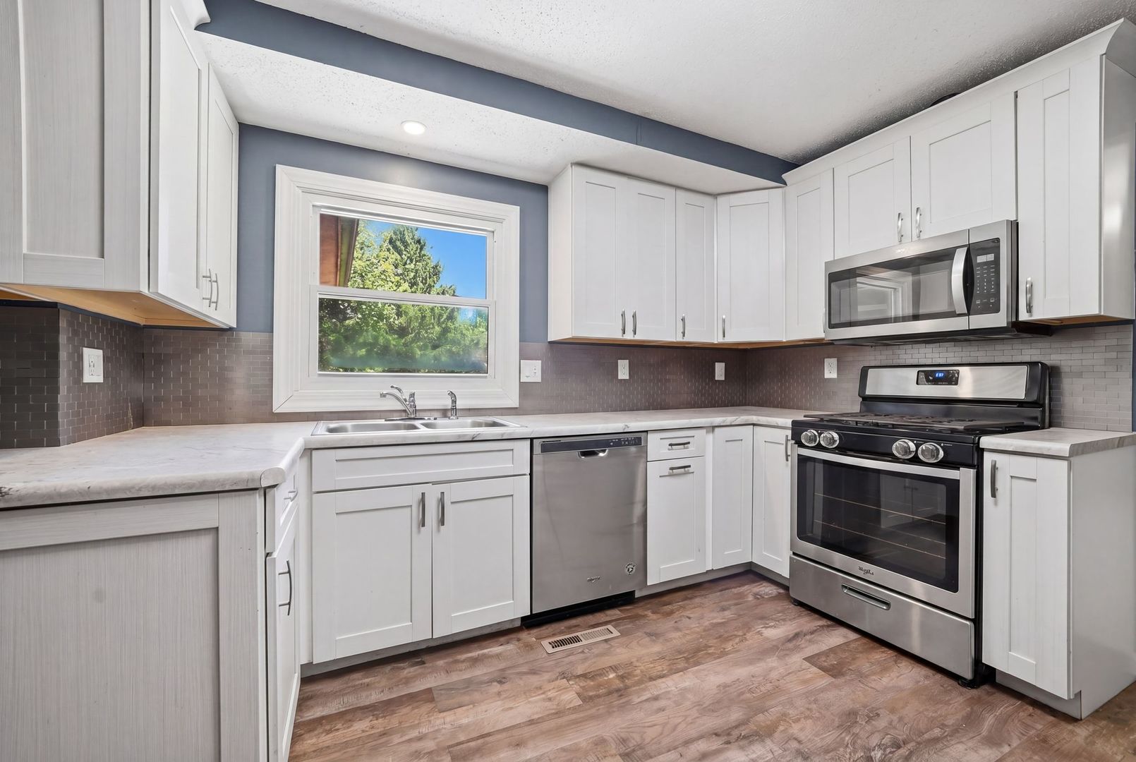 5645 Beebe Drive Rochelle, IL 61068 - Photo 12 of 43 a kitchen with stainless steel appliances granite countertop a stove a sink and a microwave