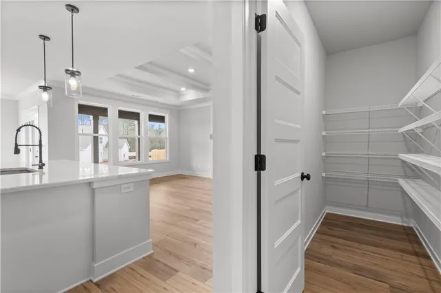 a kitchen with stainless steel appliances granite countertop a sink a oven and a wooden floor