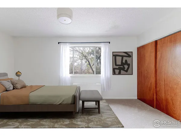 a bedroom with a bed and a painting on the wall