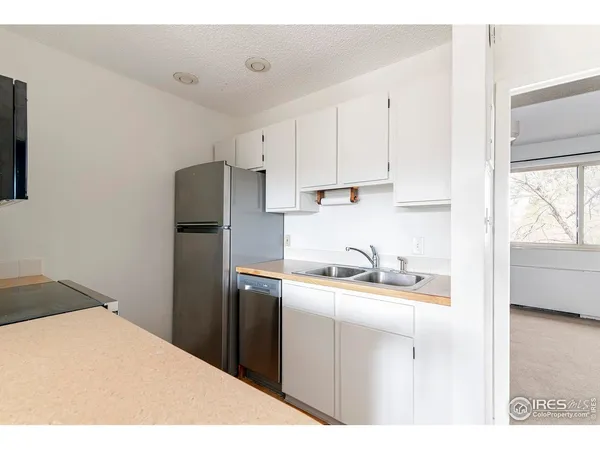 a kitchen with a sink a refrigerator and window