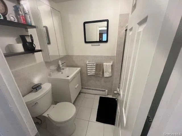 a white toilet sitting next to a bathroom sink and a mirror