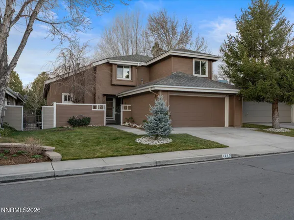 a front view of a house with a yard and a garage